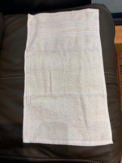 A white cotton hand towel with horizontal ribbed stripes 