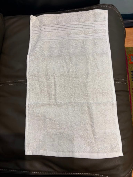 A white cotton hand towel with horizontal ribbed stripes 